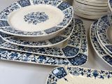 many plates and bowls on the table with blue and white designs