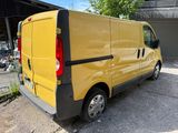 yellow van parked in front of a garage with other vehicles in the background