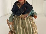 a figurine of an old woman sitting on a chair