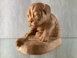 statue d'un chien posé sur un rocher, sur une table en verre