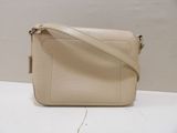 a white purse sitting on top of a table next to a wall
