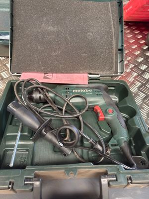 a green tool box with tools in it on a table