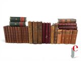 several old books stacked on top of each other on a white surface