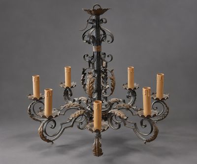 un grand lustre en fer forgé à cinq bougies
