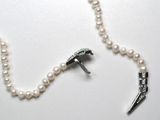 a pearl necklace with a bird charm attached to it
