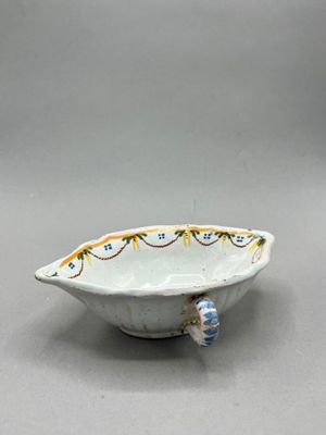 a small white bowl with a blue bead on it