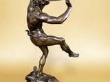 bronze statue of a man with a bow on a marble base