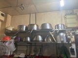 many pots and pans on the shelves in the kitchen
