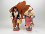 two figurines of people with umbrellas on a white background