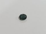 a green tourmaline stone on a white surface