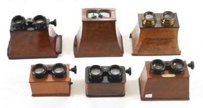 six different types of antique telephones on display on a white surface