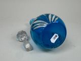 a small blue glass object with a tag on it