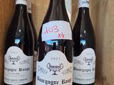 three bottles of red wine are sitting in a wooden box