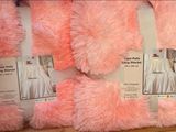 several pink and white fluffy pillows on display in a store