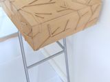 a wooden table with a metal stand in the corner