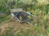 a trash can sitting in the middle of a field