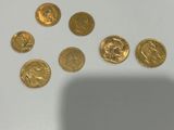 some gold coins sitting on top of a table next to a shadow of a person