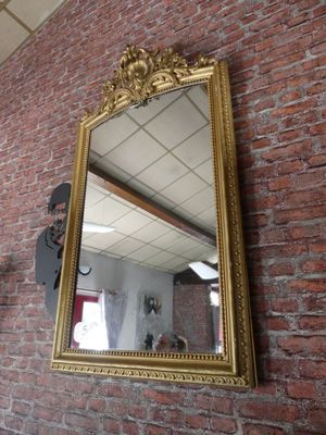 un miroir accroché au mur, à côté d'un mur en briques