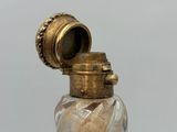 an image of a glass bottle with a gold lid and a gold cap