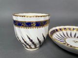 two cups and a saucer are sitting on a table