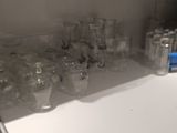 bottles and glasses are lined up on a counter in a kitchen
