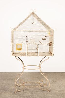 une cage blanche avec un oiseau à l'intérieur