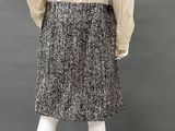 a mannequin mannequin wearing a beige shirt and black and white skirt