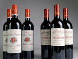 four bottles of red wine are lined up on a table