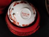 a white and red bowl with a red lid on a table