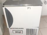 an image of a small white refrigerator in a bathroom