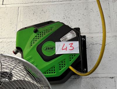 a green blower sitting next to a fan on the wall