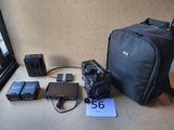 un appareil photo et d'autres appareils électroniques posés sur une table près d'une fenêtre