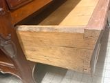 a wooden bed with a drawer in the middle of it
