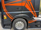 a black and orange semi truck parked in a parking lot