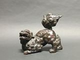 an old bronze statue of a dog on a gray background