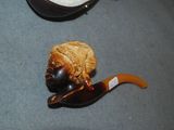 a wooden pipe with a face on it next to a pair of shoes