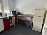 a small kitchen with a refrigerator and a microwave in it