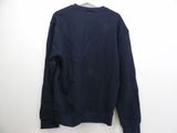 a navy sweatshirt hanging on a hanger against a white wall