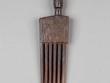 a small wooden comb with a face on top of it