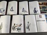 many books with drawings of people on them on a table