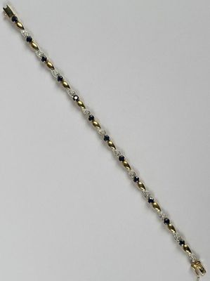 un gros plan d'un bracelet en perles dorées et noires posé sur une surface blanche