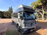 the mercedes bus is parked on the side of the road