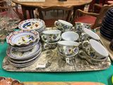 de nombreuses assiettes et tasses posées sur un plateau posé sur une table