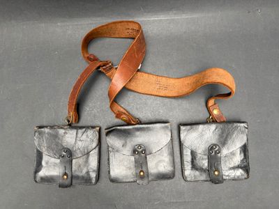 trois porte-monnaie en cuir auxquels est suspendue une lanière en cuir