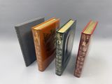 trois livres posés l'un à côté de l'autre sur une surface blanche