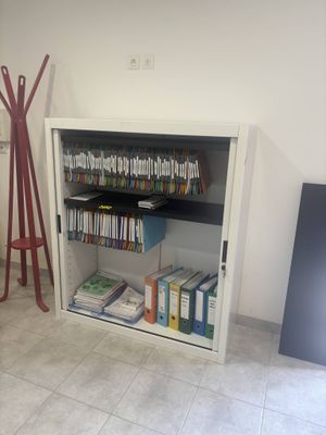 une bibliothèque remplie de livres, dans un coin de la pièce