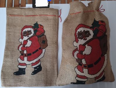 two bags with santa claus on them hanging on a wall