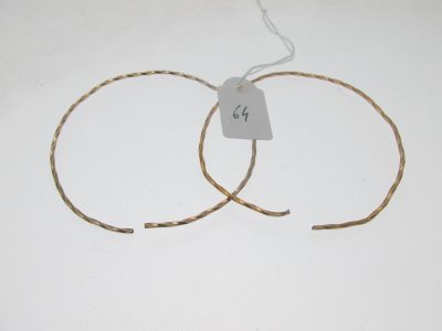 deux paires de boucles d'oreilles créoles en or avec une étiquette de prix sur fond blanc