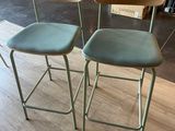 two green chairs sitting on top of a wooden floor next to each other