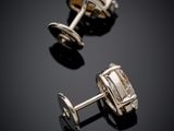 une paire de boutons de manchette en argent sur fond noir